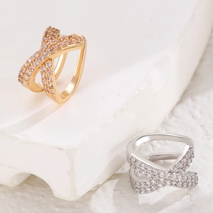 Macro detail of criss-cross ear cuff with inlaid zircons in gold and silver finish