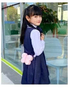 Girl wearing a pink butterfly silicone pop-it shoulder bag with a rainbow strap