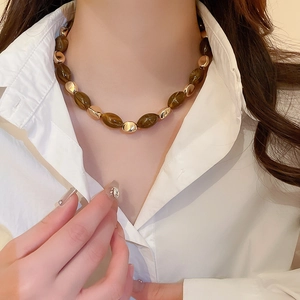 Close-up of vintage brown amber resin beads and gold textured beads on necklace