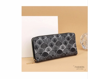 Detail of a vintage-style long wallet with black fan pattern and golden metal zipper