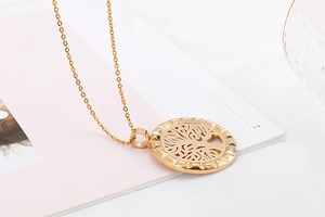 Macro detail of gold tree of life circular pendant with intricate hollow engraving