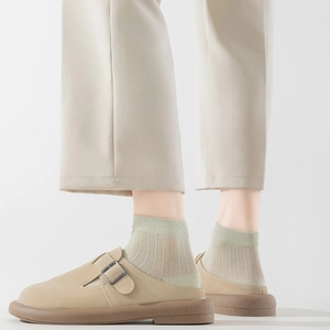 Minimalistische beige lederen muiltjes met dikke bruine rubberen zool en metalen gesp