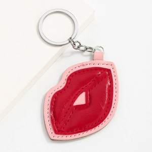Red and pink heart lip leather keychain accessory with silver metal ring on white surface