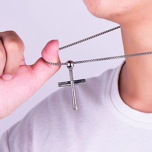 Close-up of silver stainless steel baseball bat cross pendant necklace on a model