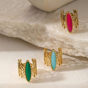 Macro shot of three gold-plated butterfly wing rings with oval gemstones in green and blue