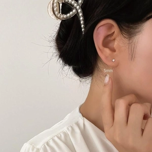 Detailed view of 5mm silver stud earrings with sparkling cubic zirconia on model