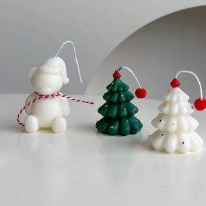 Detailed view of handmade Christmas tree and polar bear scented candles for holiday gifts