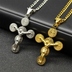 Détail des colliers croisés superposés en or et argent avec médailles religieuses gravées