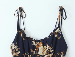 Detail of ruffled neckline and bow tie shoulder straps on navy floral slip dress