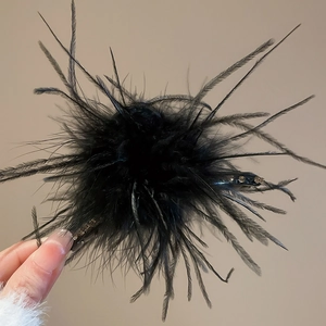 Macro shot of elegant black feather hair claw clip with delicate rhinestone embellishments