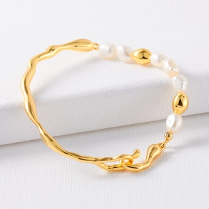 Detail of French half-bangle bracelet with gold metal chain and natural baroque pearls