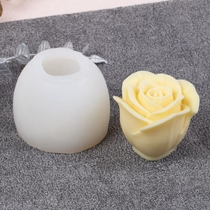 Detail showing white silicone rose mold with finished beige wax flower on grey fabric