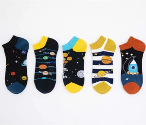 Close-up of five pairs of space-themed men's ankle socks with rocket and planet patterns