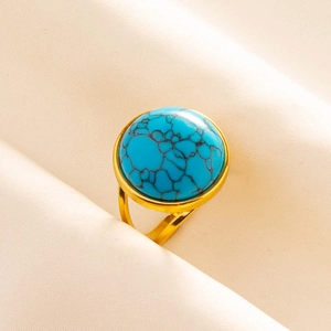 Detail of round turquoise stone with black veins on a gold plated adjustable ring