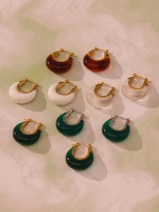 Variety of C-shaped resin moon earrings in multi-colors on marble texture surface