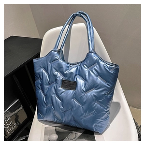 Detailaufnahme der metallic-blauen gesteppten Tragetasche mit geometrischem Muster