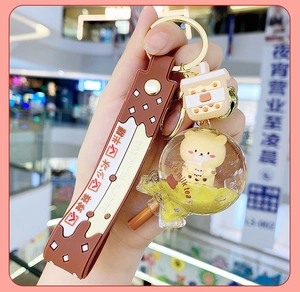 Detail of liquid bear milk tea keychain with brown rubber strap and golden buckle
