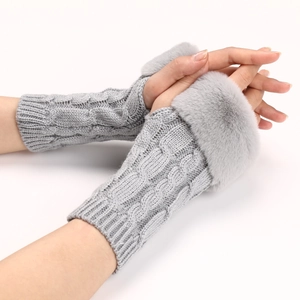 Detailed texture of light grey cable knit arm warmers with plush faux fur trim cuffs