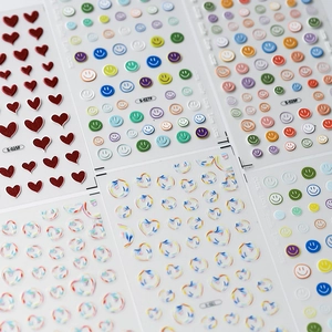 Minimalist 3D nail art stickers with glitter hearts and colorful smiley faces set