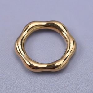 Close-up of a polished golden wave-shaped ring with 304 stainless steel texture