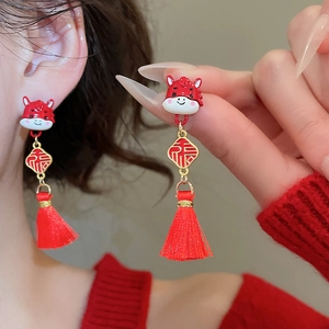 Detailed shot of red enamel zodiac earrings with lucky character and long tassels