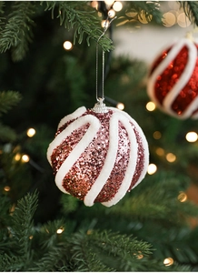 Nahaufnahme von rosa und roten Pailletten-Weihnachtskugeln mit weißen Plüschstreifen