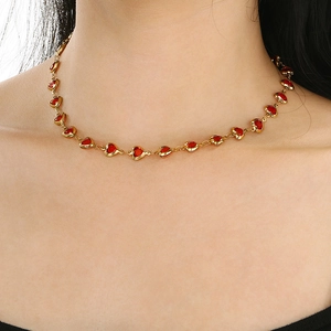 Close-up of gold stainless steel necklace with red glass hearts worn on a model
