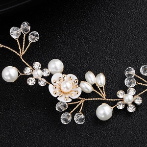 Détail du bandeau fleuri fait main avec des perles blanches et des cristaux brillants