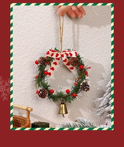 Close-up of Christmas wreath with red berries, pine cones and a brass bell decoration