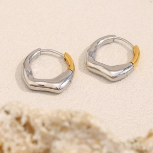 Detailed view of irregular geometric two-tone earrings in polished silver and 18K gold finish