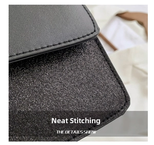 Detail shot of black leather flap and glitter fabric with neat stitching on shoulder bag