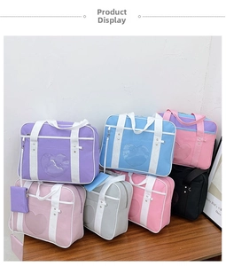 Detail of stacked Ita Bags in various colors featuring heart-shaped clear windows and straps