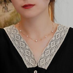 Detail of natural pearl gold bead necklace on neck showing elegant minimalist length