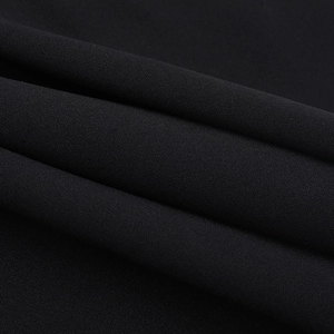 Vue macro de la texture textile noire de haute qualité et du tissage fin sur la robe
