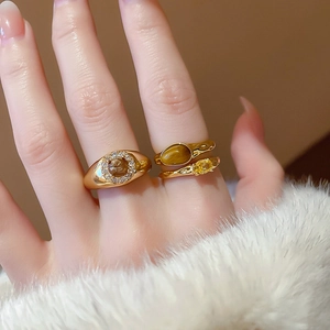 Close-up of vintage gold rings with brown tiger eye and yellow zircon on model hand
