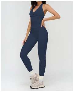 Detail view of navy blue V-neck halter yoga top and high-waist leggings with white socks