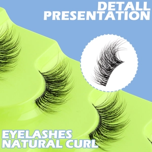 Macro detail of natural curled black half false eyelashes on a bright green tray