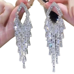 Silver fringe tassel earrings with geometric zircon stones shown in a hand-held close-up