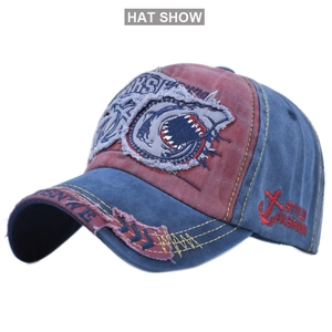 Detailed close-up of vintage distressed denim baseball cap with shark embroidery patch
