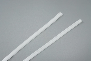Gros plan sur des bandes en tissu blanc plissé avec des coutures détaillées sur fond gris