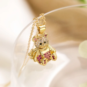 Macro detail of 18K gold plated bear pendant with sparkling pink and clear crystals