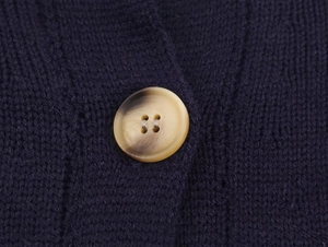 Detailed macro view of navy knit fabric with premium amber yellow buttons