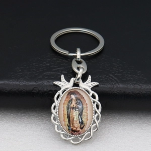 Detailed macro view of silver Our Lady of Guadalupe keychain pendant with ornate bird motifs