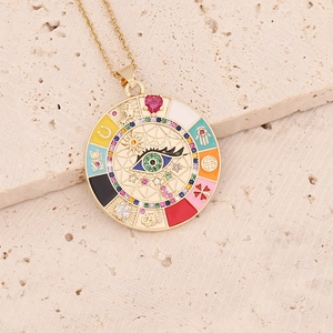 Gold round pendant necklace with colorful enamel eye design on textured stone