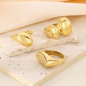 Tre anelli geometrici organici in acciaio inossidabile placcato oro 18k su pietra beige