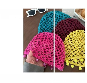 Detail of colorful handmade crochet hats with decorative bead tassels in various summer colors