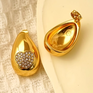 Boucles d'oreilles dorées en forme de goutte avec cœur en strass sur métal poli brillant