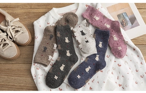 Flat lay of five autumn-winter wool knit socks with cat silhouette and red heart patterns