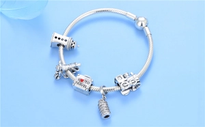 Detail view of S925 silver travel charms featuring lighthouse and steam train icons