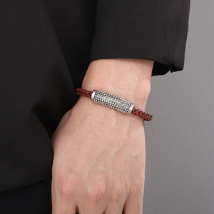 Braided reddish-brown leather bracelet with silver textured metal beads on a male wrist